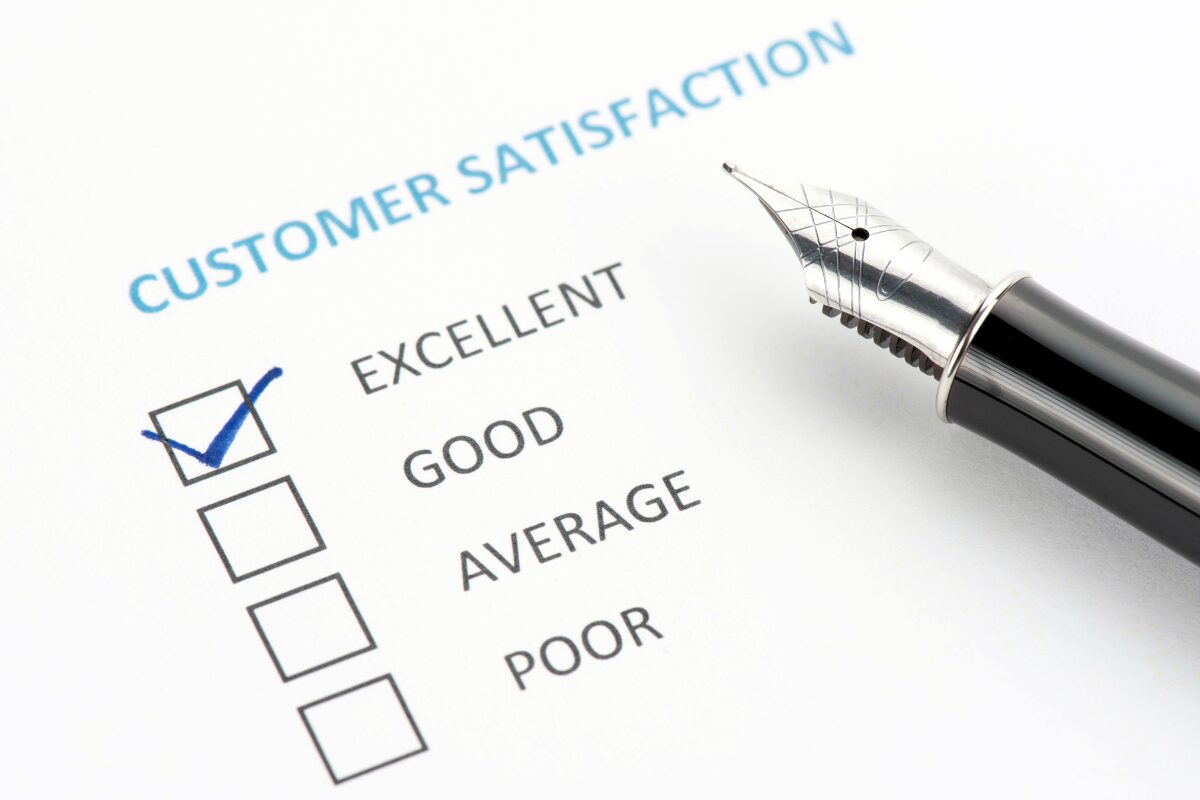 A customer satisfaction survey form with a blue checkmark in the "Excellent" box, next to a black and silver fountain pen.