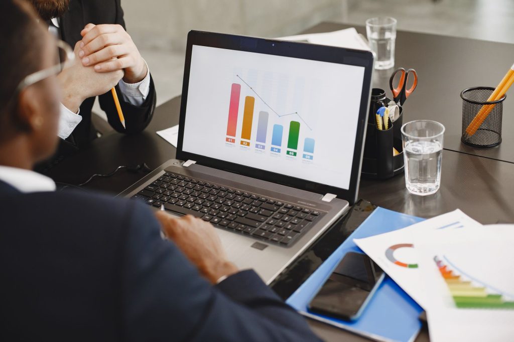 Digital marketer analyzing pay-per-click ad performance data on laptop