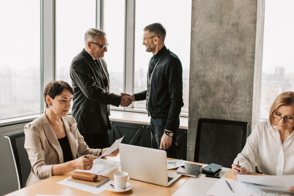 B2B business partners shaking hands after finalizing a referral partnership