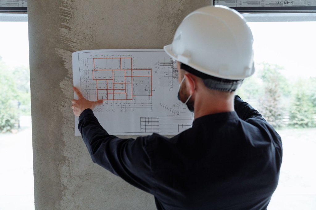 Professional roofing contractor checking blueprints on site