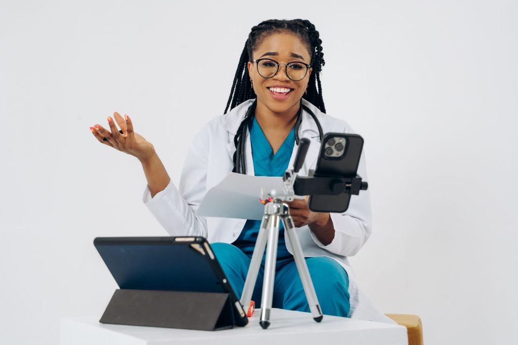 Physician recording an educational medical video on a smartphone in a clinic