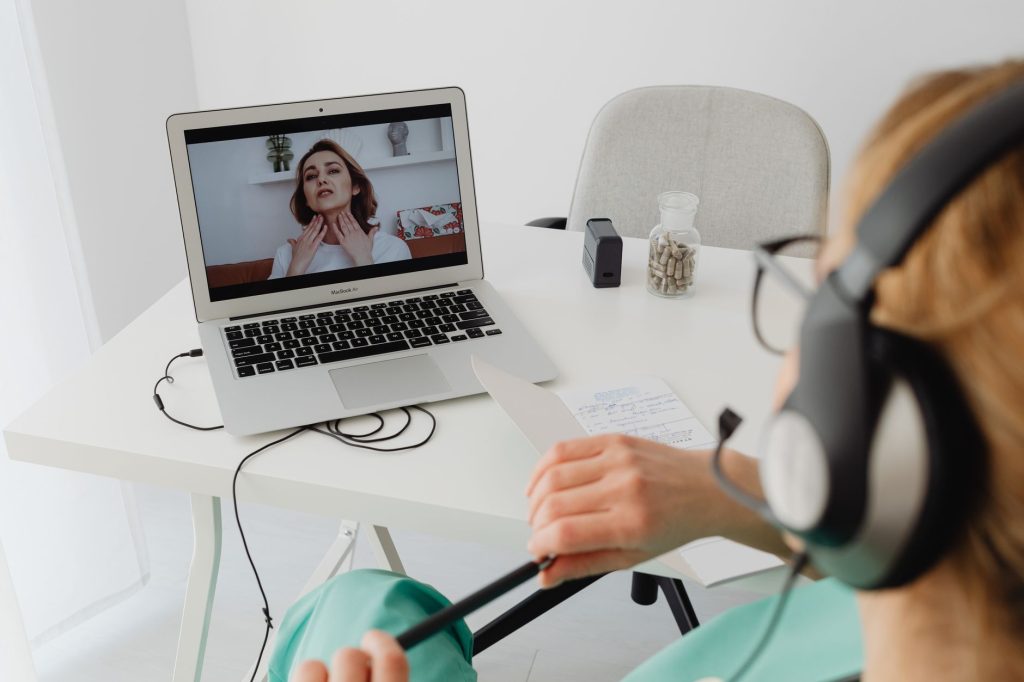 Healthcare worker responding to patient questions on a computer station