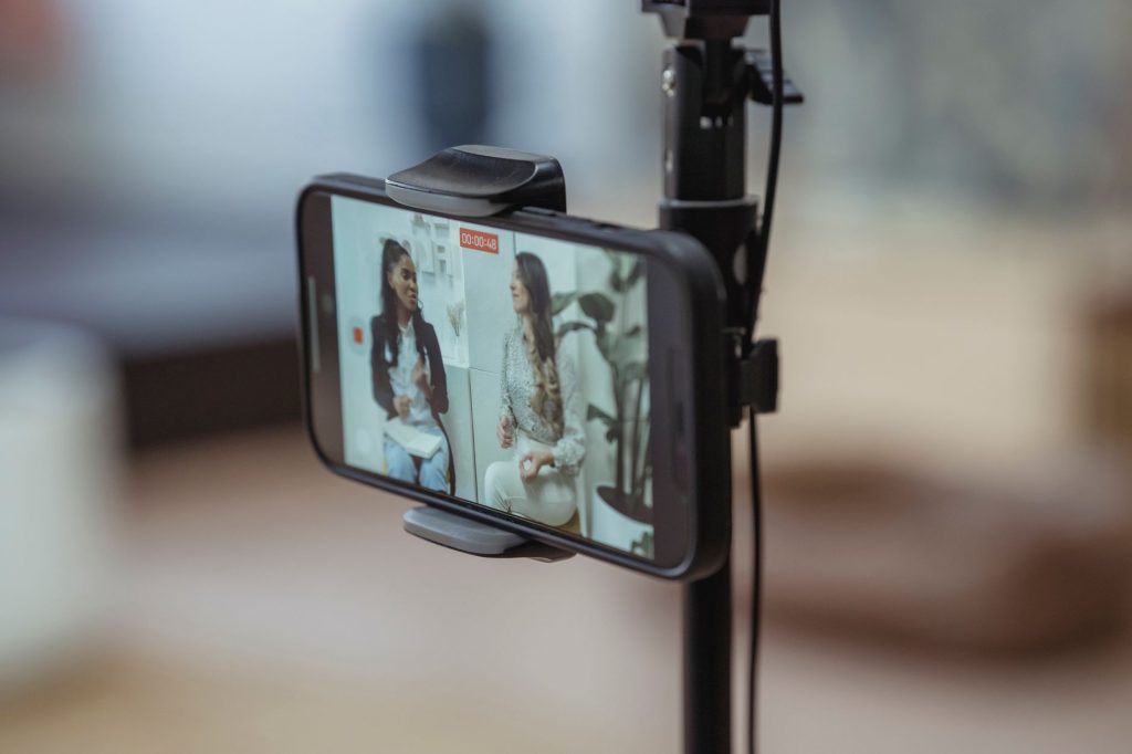 Dentist recording educational social media video clip on smartphone in dental clinic