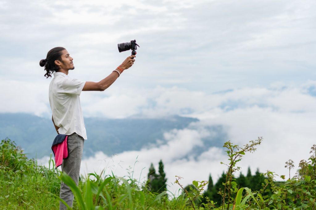 Travel content creator filming scenic balcony view with smartphone on tripod