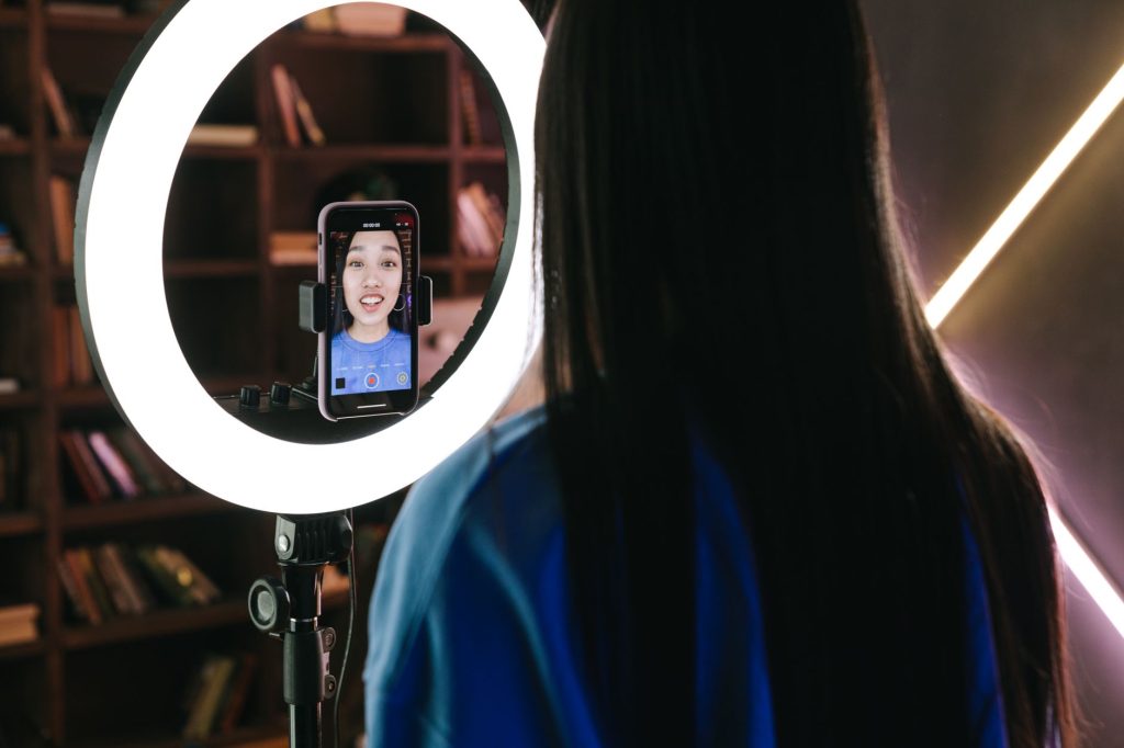 Content creator broadcasting interactive live stream with ring light setup