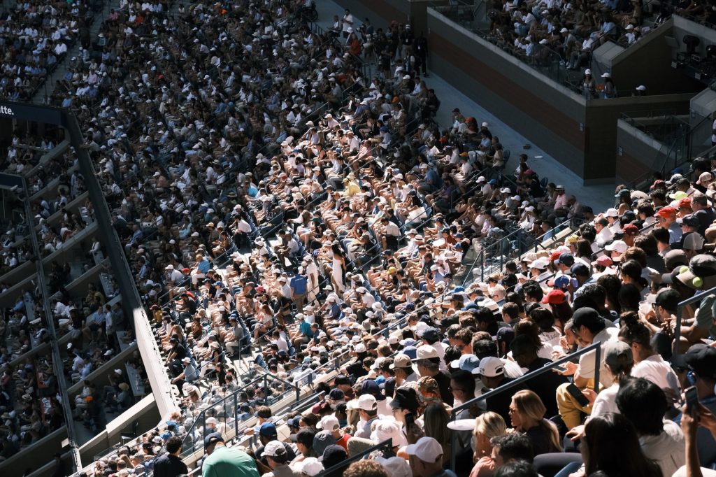 Sports fans in a stadium viewing content on a phone