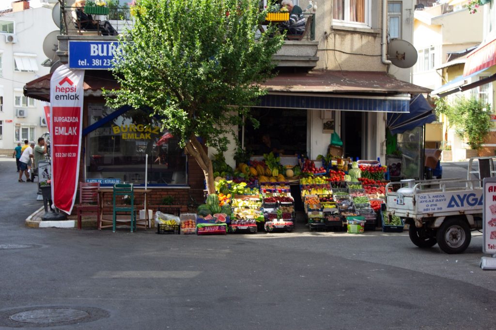 A neighborhood shop sits along a street where nearby customers pass.